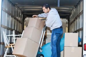 déménagement et mdph - personne qui aide au déménagement en chargeant le camion de cartons