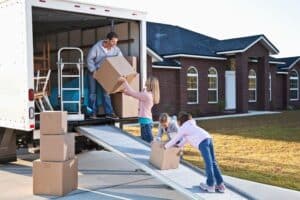 Déménagement tout inclus - famille qui porte ses cartons dans un camion